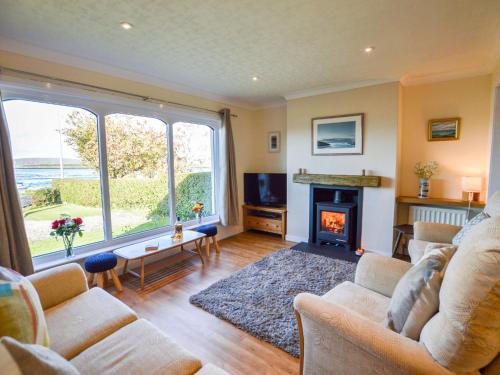 a living room with a couch and a fireplace at Holiday Home An Cala by Interhome in Oban