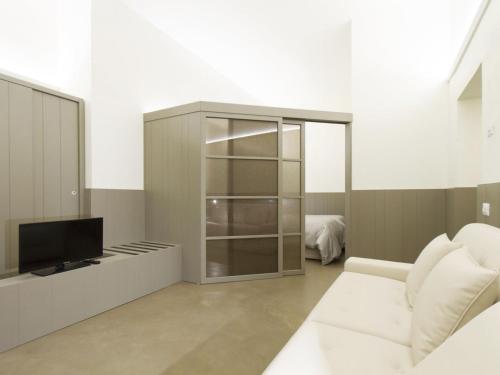 un soggiorno con TV e divano bianco di Apartment Tipologia Trilo 06 pax by Interhome a Firenze