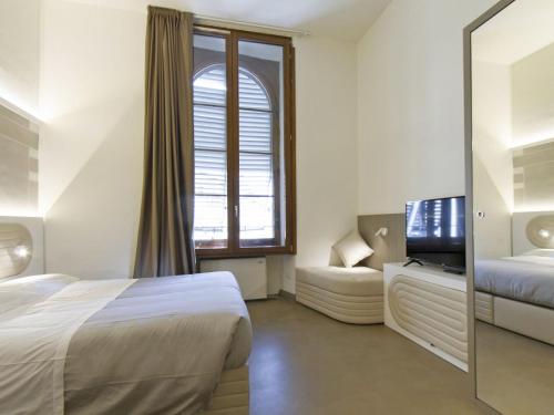 una camera d'albergo con letto e TV di Apartment Tipologia Trilo 06 pax by Interhome a Firenze