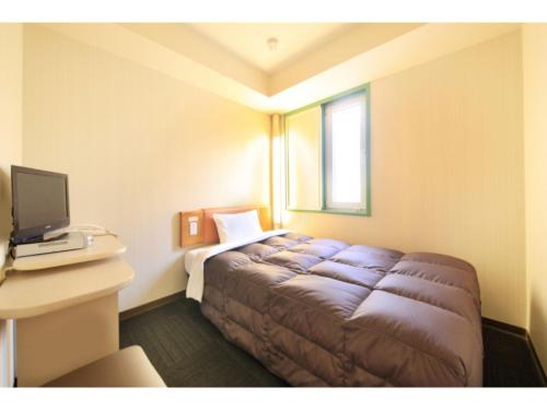 a bedroom with a bed in a room with a window at R&B Hotel Sendai Hirosedori Ekimae - Vacation STAY 39659v in Sendai