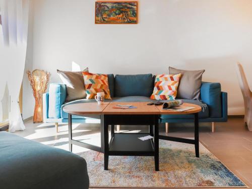 a living room with a blue couch and a table at Apartment Les Savolaires 4 by Interhome in Gryon