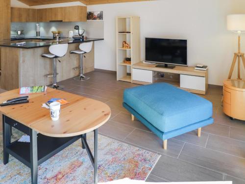 a living room with a table and a blue ottoman at Apartment Les Savolaires 4 by Interhome in Gryon