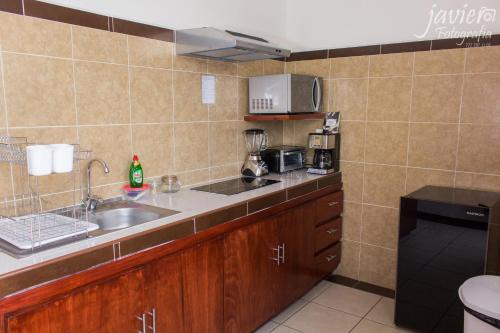 a small kitchen with a sink and a microwave at LOFTS en Cuernavaca con alberca climatizada in Cuernavaca
