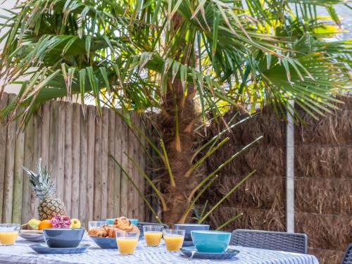 a table with a bowl of fruit and a pineapple at Apartment Le Parc des Druides-3 by Interhome in Carnac