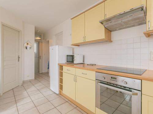La cuisine est équipée de placards jaunes et d'un réfrigérateur blanc. dans l'établissement Apartment La Centrale-9 by Interhome, à Soorts-Hossegor