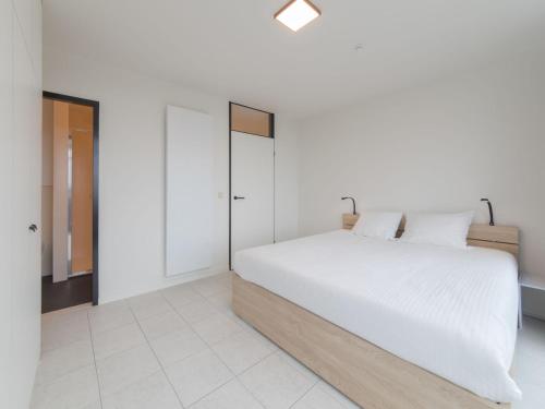 a bedroom with a white bed and white floors at Apartment Seaview 4 by Interhome in Bredene