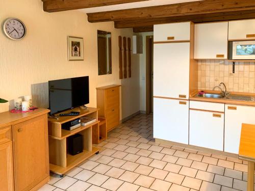 a kitchen with a white refrigerator and a tv at Apartment Peters-2 by Interhome in Barkholt