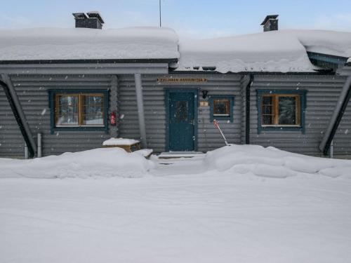 Holiday Home Karhunpesä b by Interhome في Kotila: منزل فيه باب ازرق مغطى بالثلج