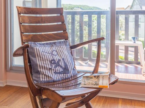 un fauteuil à bascule en bois avec un livre sur celui-ci dans l'établissement Apartment Les Terrasses de Tourgeville-4 by Interhome, à Tourgéville