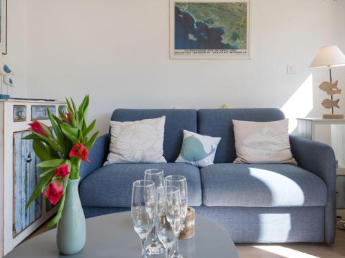 un salon avec un canapé bleu et des verres sur une table dans l'établissement Apartment Ty Bihan-3 by Interhome, à Carnac