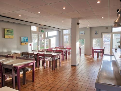 une salle à manger avec des tables et des chaises dans un restaurant dans l'établissement Auberge de Jeunesse HI Boulogne-sur-Mer, à Boulogne-sur-Mer