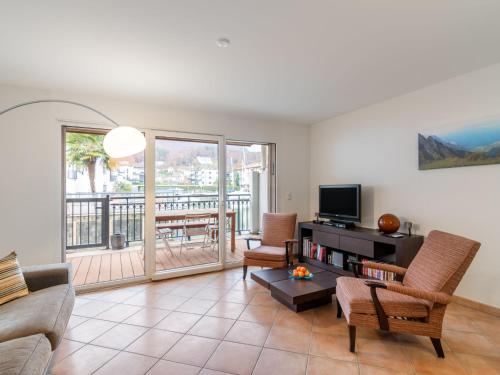 een woonkamer met een bank en een tv bij Apartment Tasman 15-R by Interhome in Bouveret