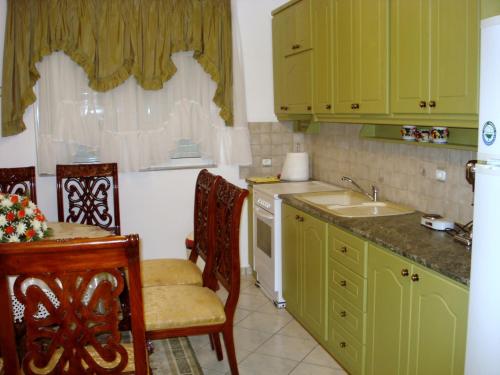 uma cozinha com armários verdes e um lavatório em Kristallia Rooms em Monastiraki