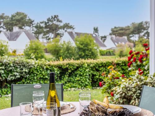 a table with a bottle of wine and a plate of food at Studio Village de Légenèse by Interhome in Carnac