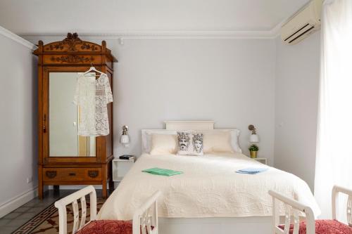 een slaapkamer met een bed met een spiegel en 2 stoelen bij Casa do Re in Catania