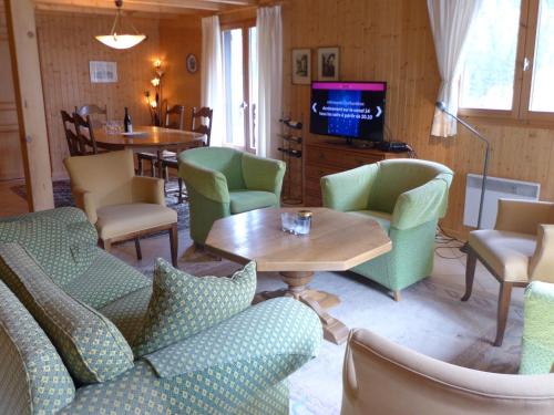- un salon avec des chaises, une table et une télévision dans l'établissement Chalet le Jet d'Eau 19 by Interhome, à Châtel