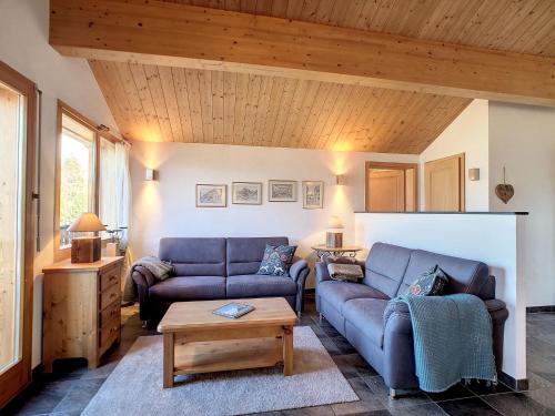 a living room with two blue couches and a wooden ceiling at Chalet Le Dahu by Interhome in Veysonnaz