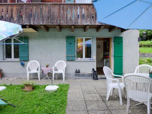 een groep witte stoelen buiten een huis bij Apartment Erika by Interhome in Meiringen