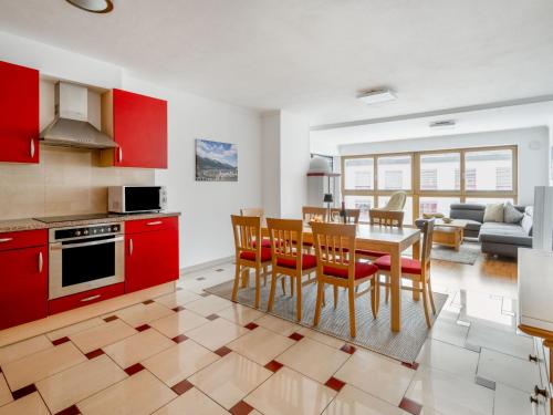 een keuken met rode kasten en een tafel en stoelen bij Apartment Papa Joe's Kuschelappartements-2 by Interhome in Schladming