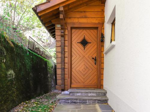 uma porta de madeira numa casa com escadas em Chalet Astrantia by Interhome em Gryon