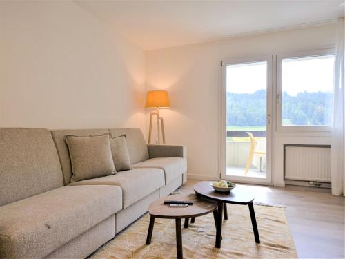 a living room with a couch and a table at Apartment Chesa Stè 8 by Interhome in Celerina