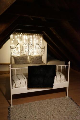LiríにあるAlbergue de Liriの白いベッド(屋根裏にライト付)
