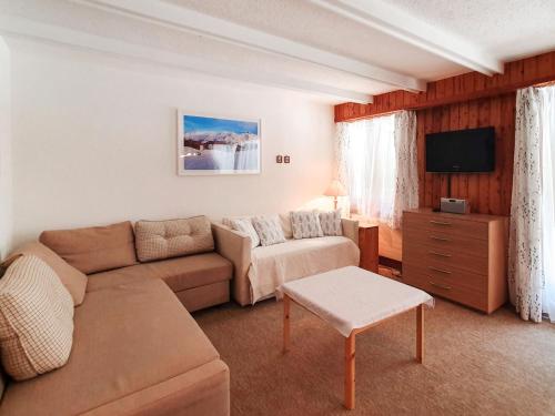 ein Wohnzimmer mit einem Sofa und einem TV in der Unterkunft Studio Panorama by Interhome in Les Collons