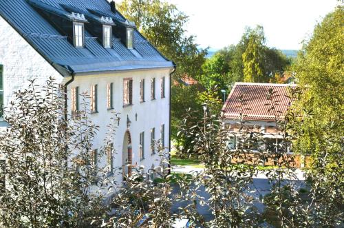a white house with a blue roof and trees at Sunderby folkhögskola Hotell & Konferens in Luleå