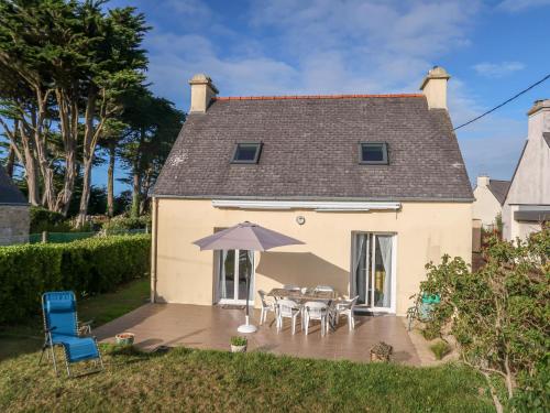 une maison avec une table, des chaises et un parasol dans l'établissement Holiday Home Les Dunes by Interhome, à Saint-Pabu