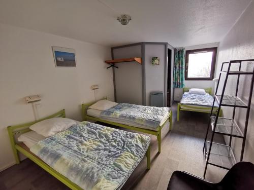two beds in a room with two bunk beds at Auberge de Jeunesse HI Boulogne-sur-Mer in Boulogne-sur-Mer