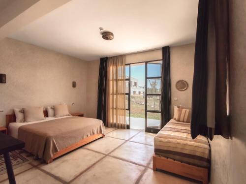 una camera con due letti e una grande finestra di Tassourt Lodge a Essaouira