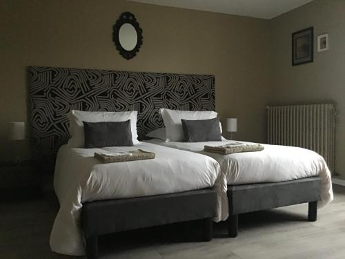 sypialnia z 2 łóżkami i dużym zagłówkiem w obiekcie Chambres d'hôtes La Maison d'Après w mieście Charolles