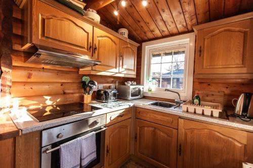 a kitchen with wooden cabinets and a stove top oven at Cabin set in the mountains By Seren Property in Trawsfynydd