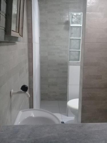 a bathroom with a white toilet and a shower at Toca da Rapoza in Salvador