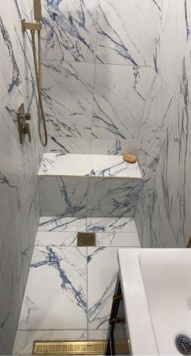 een badkamer met witte marmeren muren en een wastafel bij Harlem Brownstone in New York
