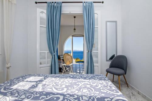 a bedroom with a bed and a view of the ocean at SUN AND SEA COTTAGE in Tinos