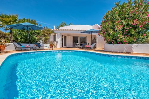 a swimming pool in front of a house at Villa Sunshine by Algarve Vacation in Armação de Pêra