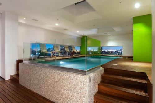 una piscina en una casa con paredes verdes en Hotel Novit, en Ciudad de México