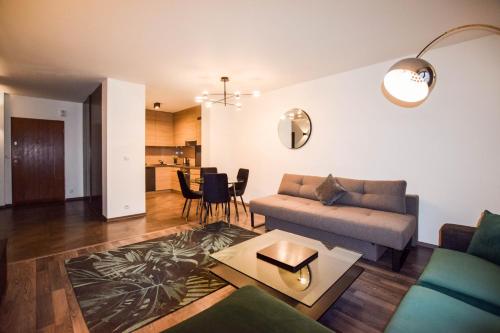 a living room with a couch and a table at Apartments Blue Angel, park free, children stay free in Krakow