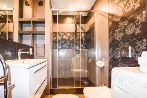 a bathroom with a shower and a toilet and a sink at Apartament z widokiem na Wawel w centrum miasta in Kraków