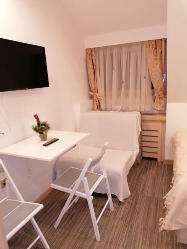 a room with a table and chairs and a tv at Kopaonik011 Konaci&WoodSide Apartments in Kopaonik
