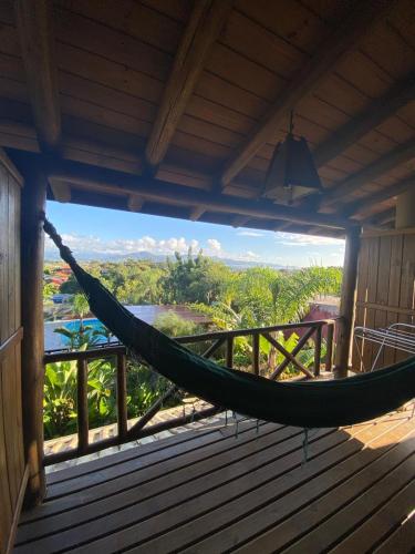 a hammock on a porch with a view at Pousada Cabanas Kaia Lua in Praia do Rosa