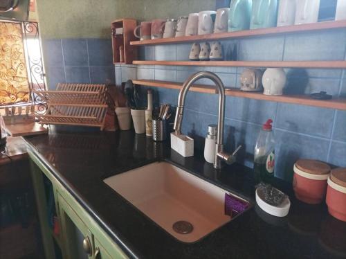 a kitchen with a sink and a black counter top at קטלב kta-love in Kammon