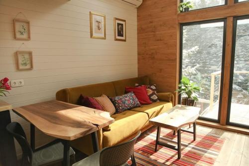 a living room with a couch and a table at Шале DEREVA in Yablunytsya