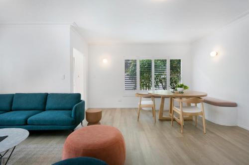 a living room with a blue couch and a table at Spacious 4-Bed Villa with Mediterranean Charm in Gold Coast