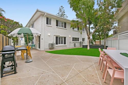 a patio with a table and chairs and an umbrella at Spacious 4-Bed Villa with Mediterranean Charm in Gold Coast