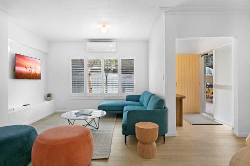 a living room with a blue couch and a table at Spacious 4-Bed Villa with Mediterranean Charm in Gold Coast