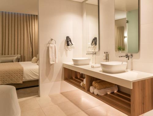 a bathroom with two sinks and a bed at Bluewater Bay Sunrise Hotel in Amsterdamhoek