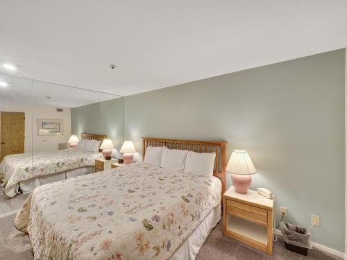 a bedroom with two beds and a large mirror at 111 Edgewater Inn in Charlevoix