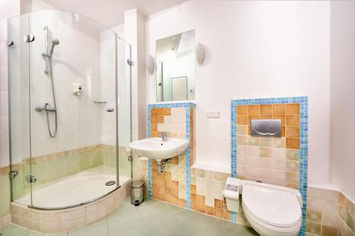 a bathroom with a toilet and a sink and a shower at Hotel Anton by DNS in Pruszków